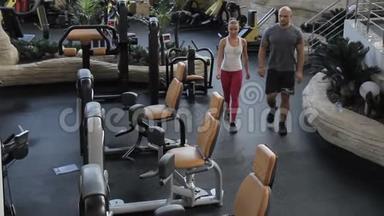 人们去健身房，坐在运动器材上训练。